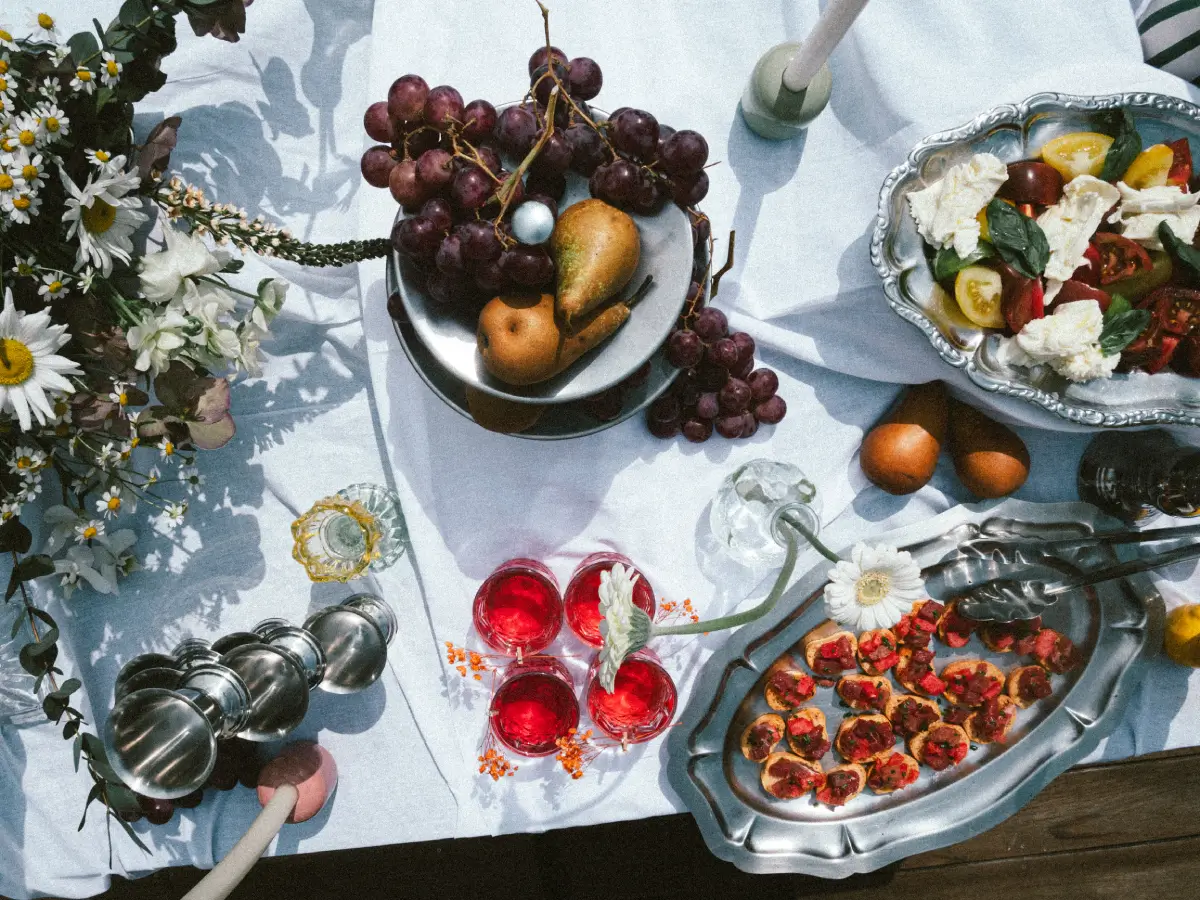 Buffet décoré avec des fleurs fraîches, présentant une variété de plats salés et sucrés, prêt pour une réception.
